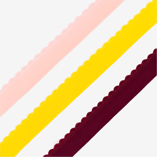 Three lengths of plush picot elastic in yellow, pink, and wine on a white background